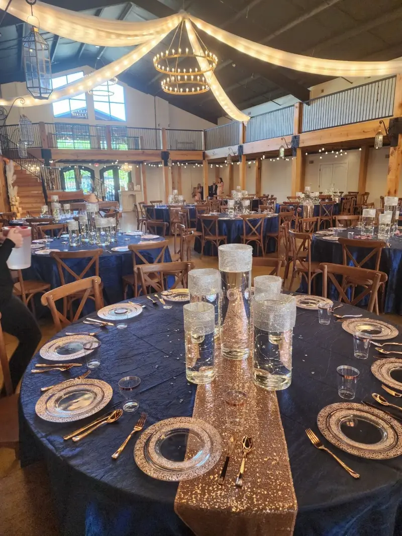 Round reception tables dressed in navy and gold with candlelit centerpieces